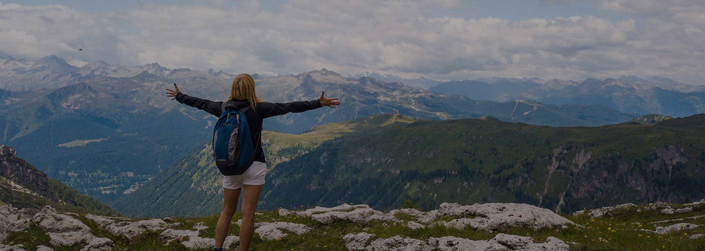 woman standing on top of mountain with arms outstretched