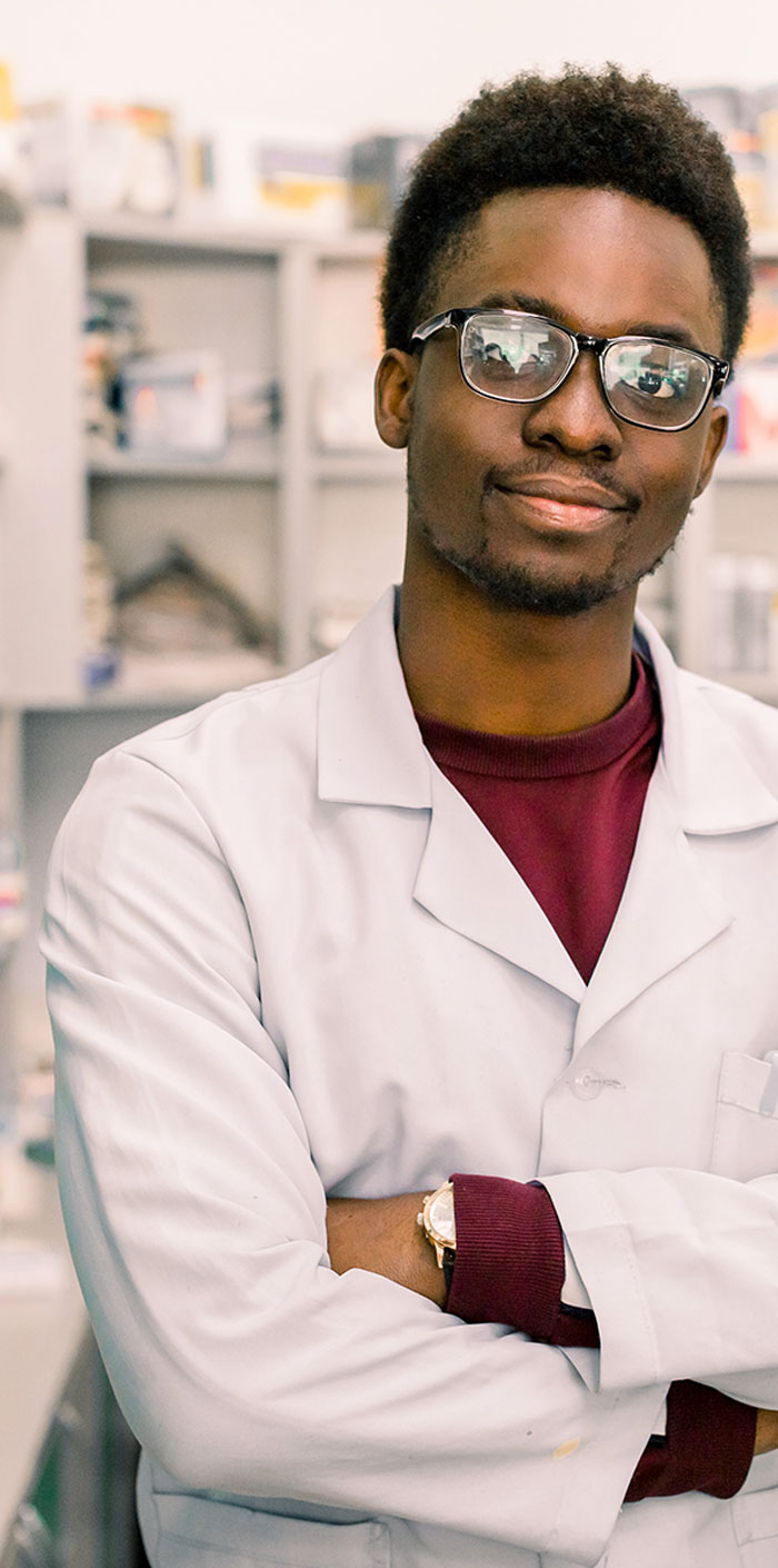 man with arms crossed in lab coat and glasses
